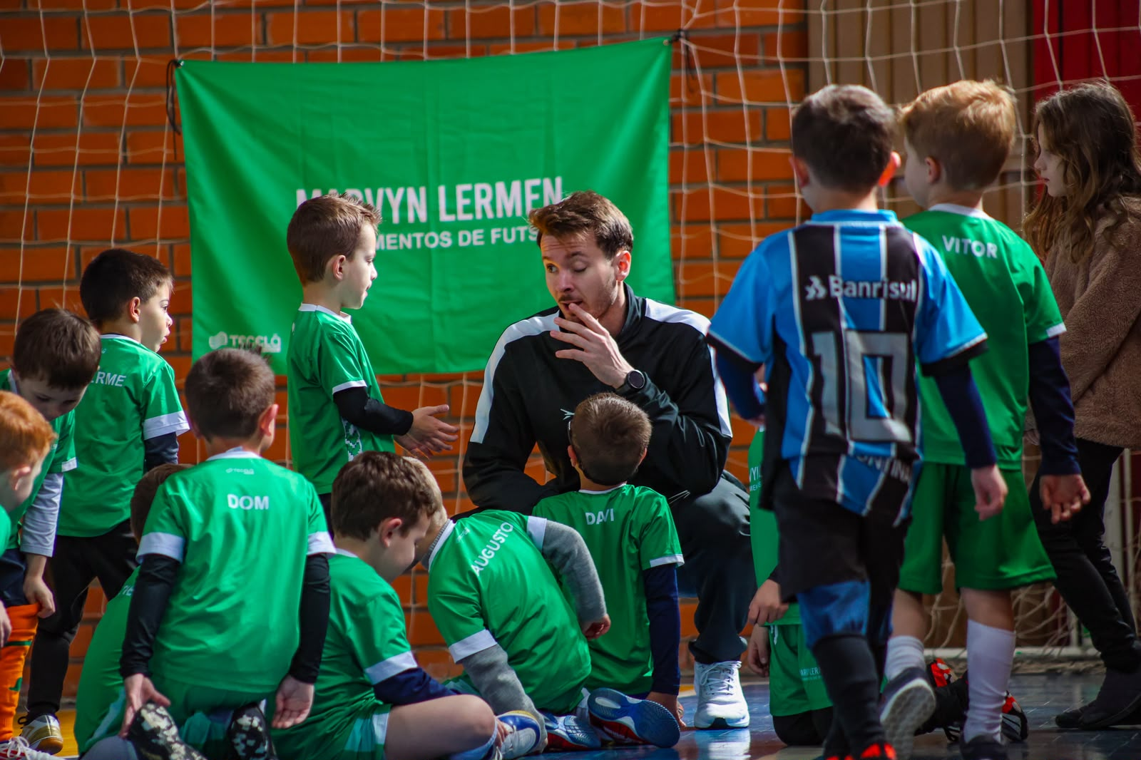 Professor Marvyn Lermen orientando crianças durante um treino de futsal